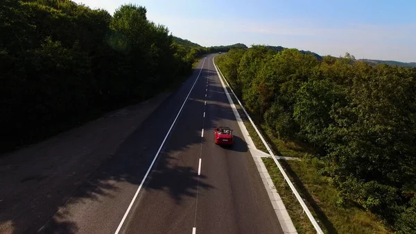 Young Couple Driving Along Country Road In Open Top Conertible Car. High quality 4k footage