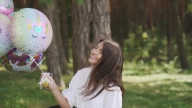 Caucasian family with two children walking hand in hand having fun in park with many balloons. Slow motion. High quality FullHD footage