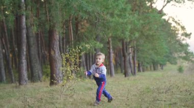 Slow motion. Kid running in nature on outside the grass in the park. Happy family kid dream concept. High quality FullHD footage
