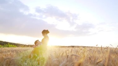 Couple in love at sunset in wheat. Red clothing. Slow motion. High quality FullHD footage