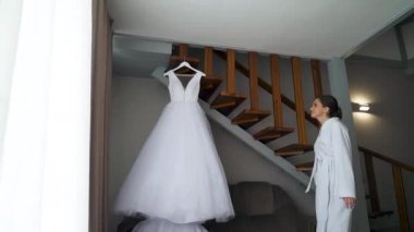 the bride takes off her wedding dress from the hanger and posing. High quality FullHD footage