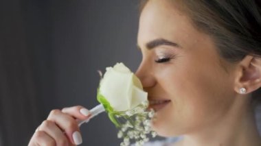 Portrait cute young female posing with flowers in her hands. Wedding photo session of charming sensual bride under veil. Pretty stylish caucasian woman. Bridal day concept. High quality FullHD footage
