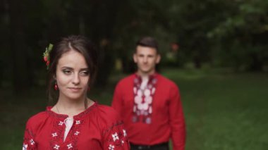 Diverse millennial couple meeting in summer park and embracing each other. Couple in national red clothing. High quality FullHD footage