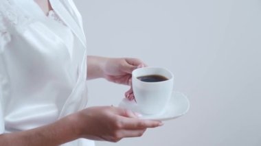Slow motion Close-up shot of a woman walking to the balcony with a cup of coffee. Enjoying morning drink. High quality FullHD footage