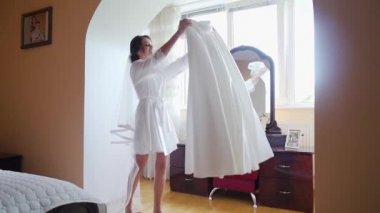 the bride takes off her wedding dress and posing near mirrow. Rotating the dress. Slow motion. High quality FullHD footage