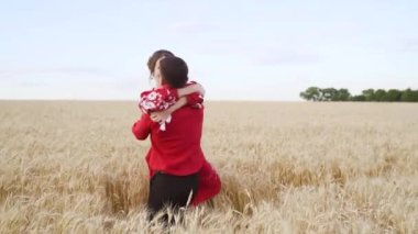 Young man kissing and spinning his girlfriend around on sunset in wheat field. Slow motion. High quality FullHD footage