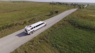 Arazide beyaz SUV limuzin gezintisi. Havadan ateş edildi. Yüksek kalite 4k görüntü