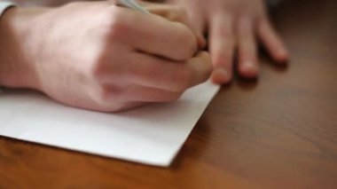 Beyaz bir kağıt üzerinde tükenmez kalemle imza atan bir adam. Önemli kayıtlar. Ofis işleri. Manzarayı kapat. Yüksek kaliteli FullHD görüntüler