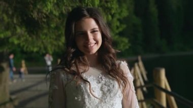 Güzel utangaç kız gülümsüyor, kendine dokunuyor ve güneş ışığıyla kameraya bakıyor. Ağır çekim. Yüksek kaliteli FullHD görüntüler