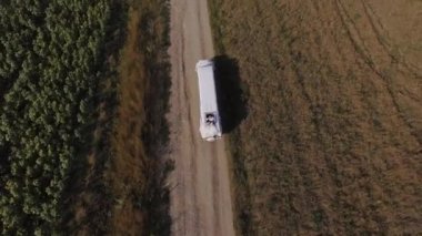 Beyaz SUV limuzin yaz sahasında yolda gidiyor. Havadan ateş edildi. Yüksek kalite 4k görüntü
