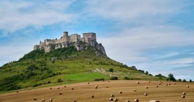 Timelaps, Ancient Castle, Spissky Hrad in Slovakya - Bleach Bypass. Arka planda bulutlar ve saman balyalarıyla. Yüksek kalite 4k görüntü