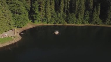 Genç çift Ukrayna 'daki Synevyr Gölü' nde bir tekneye biniyorlar. Hava görüntüsü 4K. Yüksek kalite 4k görüntü