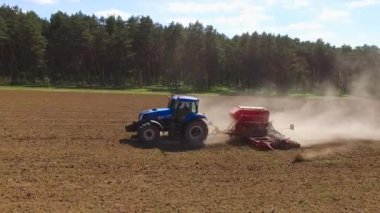 Traktör, tarım arazisine kuru mineral gübreleri yayar. Yetiştirme ve ürün veriminde mevsimsel artış. Havadan ateş edildi. Yüksek kalite 4k görüntü