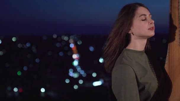 一个眼睛惊讶的女孩在夜市的背景下弹奏着管弦乐队的乐器 优质Fullhd影片 — 图库视频影像