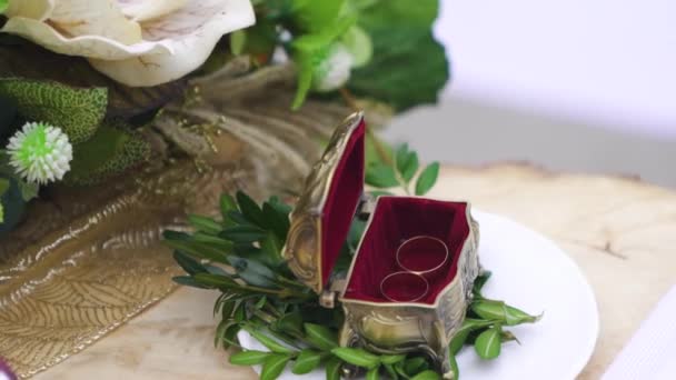 特写拍摄白色金婚戒在一个木制盒子上美丽的绿叶 优质Fullhd影片 — 图库视频影像