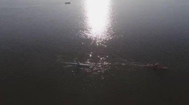 Akşamın erken saatlerinde büyük bir gölde iki kanocu ve su üzerinde güneş ışıkları. Ternopil şehri. Yüksek kalite 4k görüntü