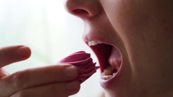 女人咬Zephyr或棉花糖和舔她的嘴唇 静态关闭侧面视图 慢动作高质量的4K镜头 — 图库视频影像