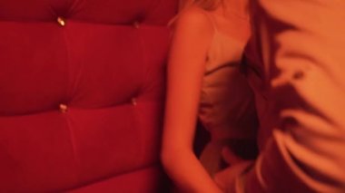 Genç ve güzel bir kadın, erkek arkadaşını şehvetle öperken aynı odada kırmızı ışıkla dikiliyor. Yüksek kalite 4k görüntü