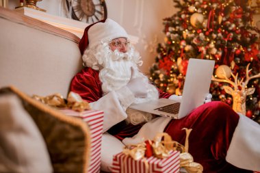 Noel Baba evinde oturuyor ve dizüstü bilgisayarında Noel 'le e-posta okuyor. Şöminenin yanında bir dilek listesi ve hediyeli bir ağaç istiyor. Yeni yıl ve Mutlu Noeller 