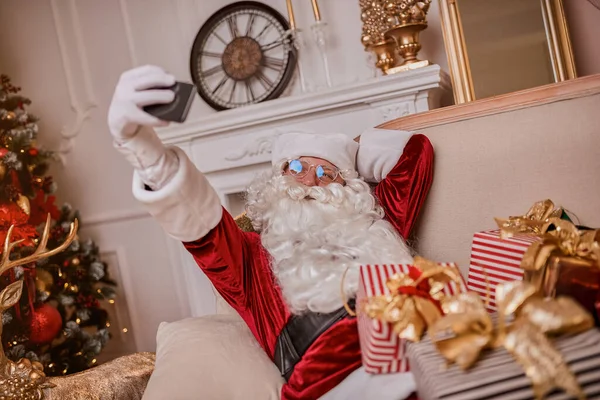 Santa Claus Sitting Couch Talking Mobile Phone Fireplace Christmas Tree — Stock Photo, Image