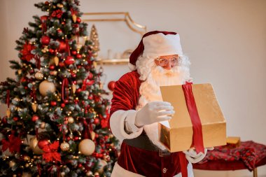 Güzel Noel ağacının yanında sihirli bir hediyeyle sürpriz Noel Baba. Yeni yıl ve Mutlu Noeller, Mutlu Noeller konsepti