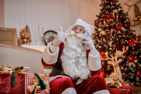 Papai Noel Sentado Sofá Falando Celular Perto Lareira Árvore Natal — Fotografia de Stock