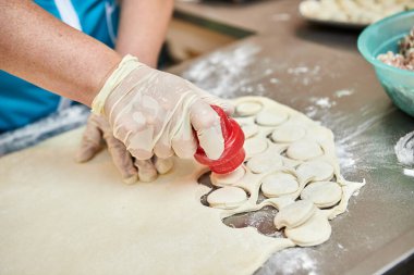 Şefin elleri arka planda el yapımı ravioli ve un serpiştirilmiş khinkali ile yapılan hamur tatlısı pişiriyor. Lezzetli ev yemekleri..