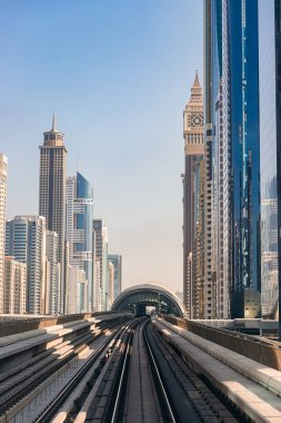 Dubai, Birleşik Arap Emirlikleri - 06 Kasım 2021: Dubai metrosu gökdelenlerin arka planında. Metro vagonundan şehrin manzarası.