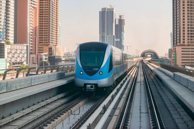 Dubai, Birleşik Arap Emirlikleri - 06 Kasım 2021: Dubai metro treni gökdelenlerin arka planında. Meşhur metro kırmızı hattı.