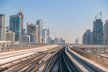 Dubai, Birleşik Arap Emirlikleri - 06 Kasım 2021: Dubai metrosu gökdelenlerin arka planında. Metro vagonundan şehrin manzarası.