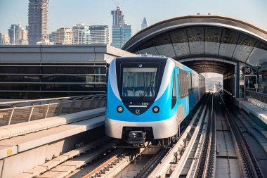 Dubai, Birleşik Arap Emirlikleri - 06 Kasım 2021: Dubai metro treni gökdelenlerin arka planında. Meşhur metro kırmızı hattı.