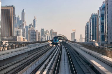Dubai, Birleşik Arap Emirlikleri - 06 Kasım 2021: Dubai metro treni gökdelenlerin arka planında. Meşhur metro kırmızı hattı.