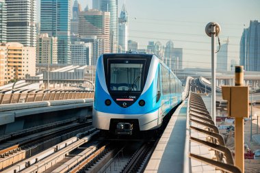 Dubai, Birleşik Arap Emirlikleri - 06 Kasım 2021: Dubai metro treni gökdelenlerin arka planında. Meşhur metro kırmızı hattı.