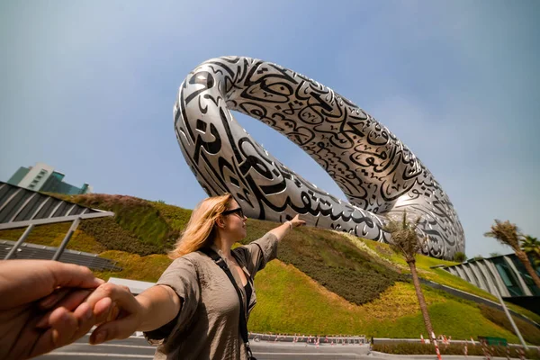 DUBAI / United Arab Emirates-8 / 11 / 2021 - Dubai şehir merkezinde ExPO 2020 için inşa edilen Geleceğin Müzesi yakınlarındaki Kadın Turist, Dış yüzeyinde Arap şiiri olan İnanılmaz Modern Mimari Tasarımı