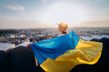 Ukrayna için dua edin. Bir adam Ukrayna bayrağının yanında duruyor ve gün batımında Lviv 'de barış için dua ediyor. Ukrayna halkının bir sembolü, bağımsızlık ve güç..
