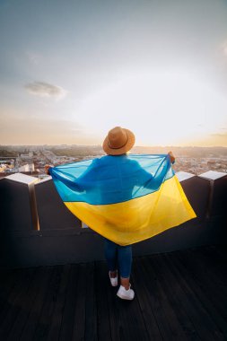 Ukrayna için dua edin. Bir adam Ukrayna bayrağının yanında duruyor ve gün batımında Lviv 'de barış için dua ediyor. Ukrayna halkının bir sembolü, bağımsızlık ve güç..