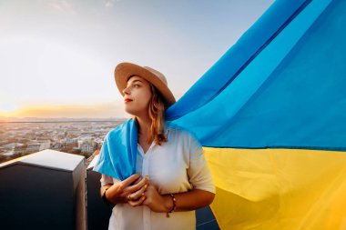 Ukrayna için dua edin. Bir adam Ukrayna bayrağının yanında duruyor ve gün batımında Lviv 'de barış için dua ediyor. Ukrayna halkının bir sembolü, bağımsızlık ve güç..