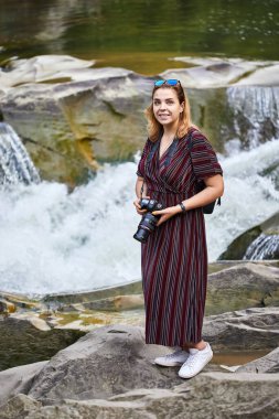 Kadın turist, Yaremche, Karpatlar, Ukrayna 'da Prut ve Şelale nehirlerinin fotoğraflarını çekiyor.