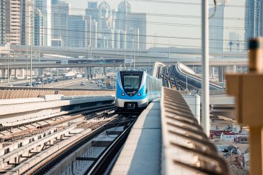 Dubai, Birleşik Arap Emirlikleri - 06 Kasım 2021: Dubai metro treni gökdelenlerin arka planında. Meşhur metro kırmızı hattı.