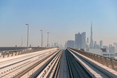 Dubai, Birleşik Arap Emirlikleri - 06 Kasım 2021: Dubai metrosu gökdelenlerin arka planında. Metro vagonundan şehrin manzarası.
