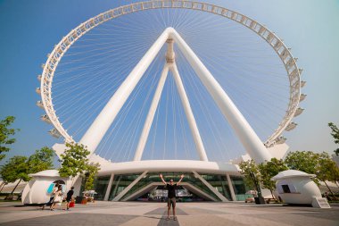 Erkek turist, dünyanın en büyük dönme dolaplarından biri olan Ain (Eye) DUBAI 'nin Bluewater adasındaki görüntüsünden zevk alarak ellerini kaldırdı. Birleşik Arap Emirlikleri 'nin en iyi turistleri arasında