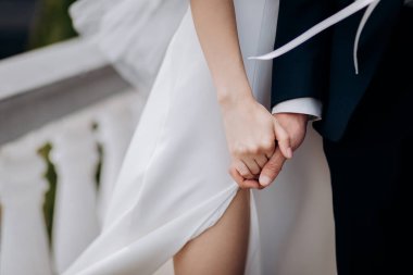 Gelin ve damat dışarıda el ele tutuşuyor, düğün teması...