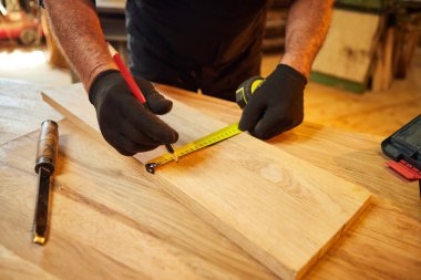 Marangoz bir ahşap ile çalışır, bir kalemle tahta işaretler ve ölçümler yapar bir marangoz atölyesinde bir parça mobilya yapmak için bir parça odun kesmek için, yakın görüş