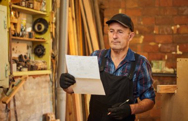 Üst düzey bir marangozun portresi marangozluk atölyesinde mobilya yapmayı planlıyor.