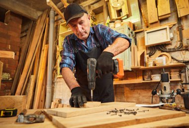 Marangozluk atölyesinde çalışan bir marangozun portresi.