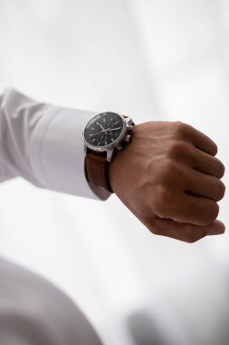 İş adamı kol saatini kontrol ediyor, saati eline alıyor, damat düğün töreninden önce hazırlanıyor. Erkekler Moda