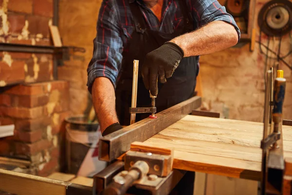 高级木匠 穿着制服 用手压木匠的木棍粘在一起 — 图库照片