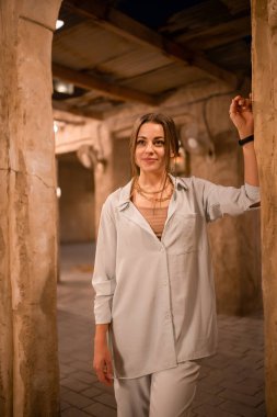 Al Seef Meraas Dubai 'de yürüyen kadın turist - geleneksel Arap mimarisine sahip eski tarihi bölge