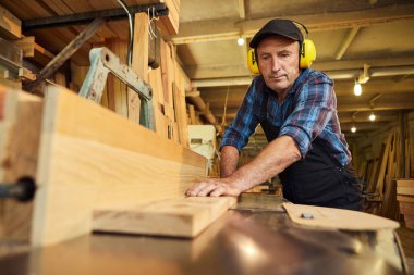 Üniformalı kıdemli marangoz marangozluk fabrikasında marangoz olarak çalışıyor.