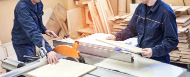 Elektrikli testere ile ahşap kesme masası. Marangozluk atölyesinde usta bir dolap ustası var. Profesyonel marangoz kereste fabrikasında tahta kesiyor. Testere makinesi